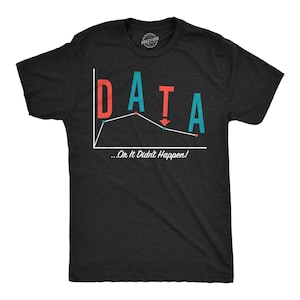 以下が含まれることがあります： 赤とティール色の文字でDATAという単語に折れ線グラフが組み込まれたデザインの黒い半袖Tシャツ。グラフの下には、白い筆記体で「...Or It Didn't Happen!」というテキストがプリントされています。Tシャツはクルーネック仕様です。