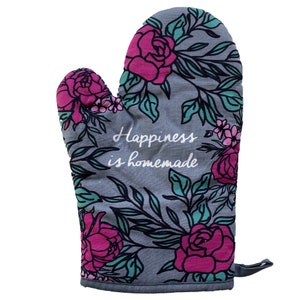 May include: Gray oven mitt with a floral pattern in shades of pink and green. The text "Happiness is homemade" is printed in white on the mitt.