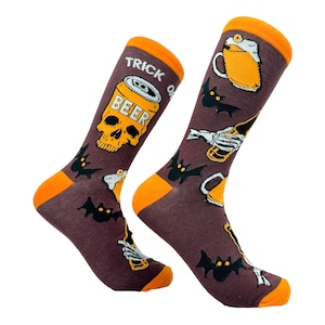 Może przedstawiać: Para brązowych i pomarańczowych skarpet z motywem Halloween. Skarpety przedstawiają czaszkę z napisem "BEER", nietoperze i kufel piwa. Na skarpetach nadrukowany jest napis "TRICK OR".