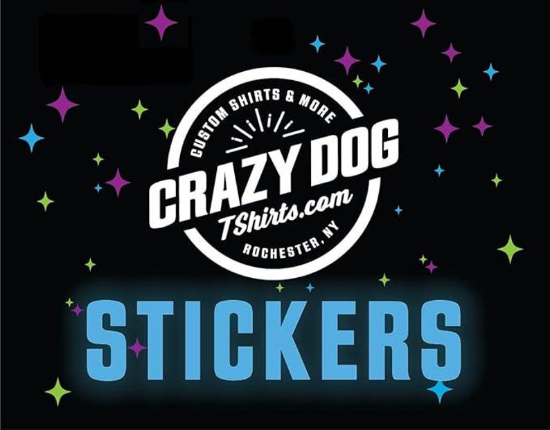 May include: Black background with colorful star shapes and the text "STICKERS" in light blue. A white circular logo in the center reads "CRAZY DOG TShirts.com ROCHESTER, NY" with the words "CUSTOM SHIRTS & MORE" around the top.
