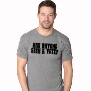 May include: A heather grey t-shirt with the text "HAS ANYONE SEEN A YETI?" printed in black.