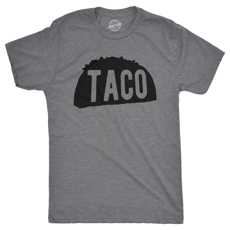 K&ouml;nnte beinhalten: Ein heidefarbenes T-Shirt mit einer schwarzen Silhouette eines Tacos und dem Wort "TACO" darauf gedruckt.