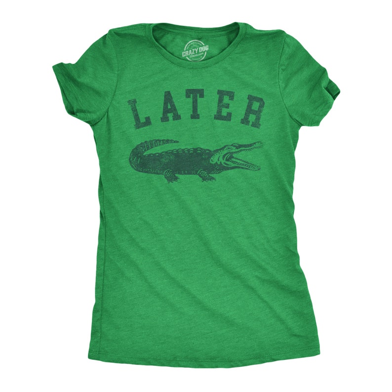 May include: Green t-shirt with the word "LATER" above a dark green alligator illustration. The shirt is a crew neck style and has short sleeves. The brand "Crazy Dog" is printed on the tag.