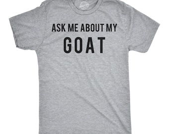 Może przedstawiać: Szary melanżowy t-shirt z krótkim rękawem z czarnym napisem "ASK ME ABOUT MY GOAT" wydrukowanym pogrubioną czcionką bezszeryfową na klatce piersiowej. Odzież posiada okrągły dekolt i standardowy krój, prezentując prosty i bezpośredni wzór.