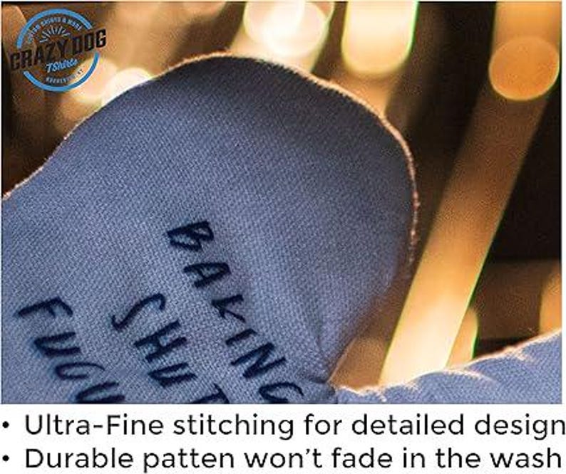 May include: Blue oven mitt with the text "Baking Sh*t Up" embroidered on it. The mitt has a detailed design with fine stitching.