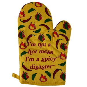May include: Yellow oven mitt with a red and green chili pepper pattern. The mitt has the text "I'm not a hot mess I'm a spicy disaster" printed on it.