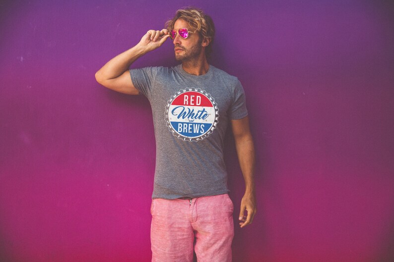 May include: A gray t-shirt with a red, white, and blue graphic of a bottle cap that says "Red White & Brews".