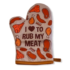 May include: A light brown oven mitt featuring a repeating pattern of various meat cuts including sausages, steaks, and chicken legs. The center displays the dark brown text I heart TO RUB MY MEAT with a heart symbol replacing the word love.