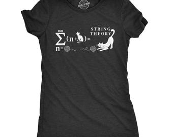 May include: A charcoal gray short-sleeve t-shirt featuring a white graphic print of a mathematical equation that reads "String Theory" with a summation symbol, a cat silhouette, and two balls of yarn with a stretching cat illustration.