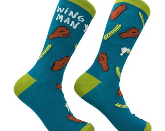 Peut inclure: Une paire de chaussettes bleu sarcelle avec un motif répétitif d'ailes de poulet marron, de branches de céleri vert clair et de taches de sauce blanches. Le texte WING MAN est imprimé en blanc sur le haut de la chaussette gauche. Les bords, talons et pointes sont vert citron.