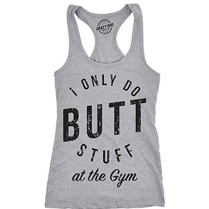 May include: A heather grey racerback tank top featuring black distressed lettering that reads I ONLY DO BUTT STUFF at the Gym. The garment has a scoop neckline and a sleeveless design with a small circular logo printed on the inner neck area.