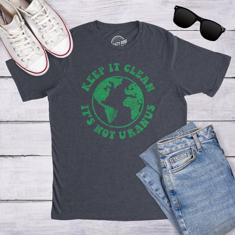 May include: A dark heather grey t-shirt with a green graphic of the Earth and the text "Keep it clean, it's not Uranus".