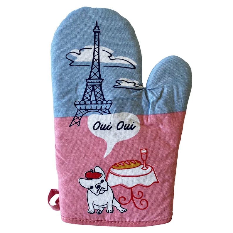 May include: Pink and blue oven mitt with a cartoon illustration of the Eiffel Tower, a French bulldog, and a table with a glass of wine and a baguette. The text "Oui Oui" is in a speech bubble.