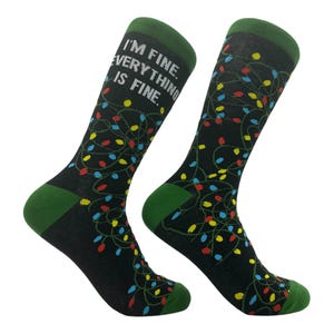 May include: A pair of black socks with a green cuff. The socks feature a pattern of colorful Christmas lights and the text "I'm fine. Everything is fine."