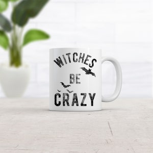 May include: White ceramic mug with black text that reads "Witches Be Crazy" and a black bat graphic.