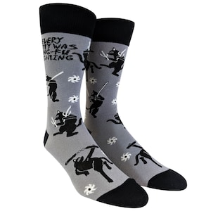 May include: A pair of gray socks with a black cat ninja design. The socks have the text "EVERY CITY WAS DOING-FU FIGHTING" on the top of the socks.