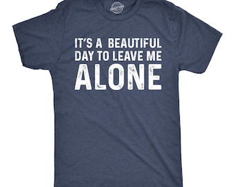 May include: A navy blue short-sleeve crew neck t-shirt with a heathered texture. The front features white distressed-style text that reads: IT'S A BEAUTIFUL DAY TO LEAVE ME ALONE. The shirt has a standard fit with a round neckline and short sleeves.