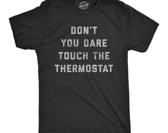 May include: A charcoal grey short-sleeve t-shirt featuring the white distressed-style text DON'T YOU DARE TOUCH THE THERMOSTAT printed in the center of the chest. The shirt has a crew neckline and a standard fit with a visible brand logo on the inner neck.