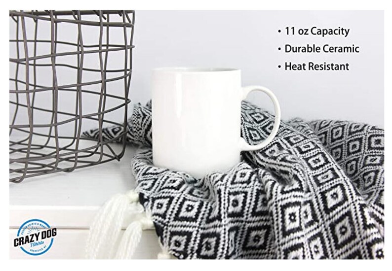 May include: White ceramic mug with a 11 ounce capacity. The mug is heat resistant and has a handle. The mug is sitting on a black and white patterned blanket.