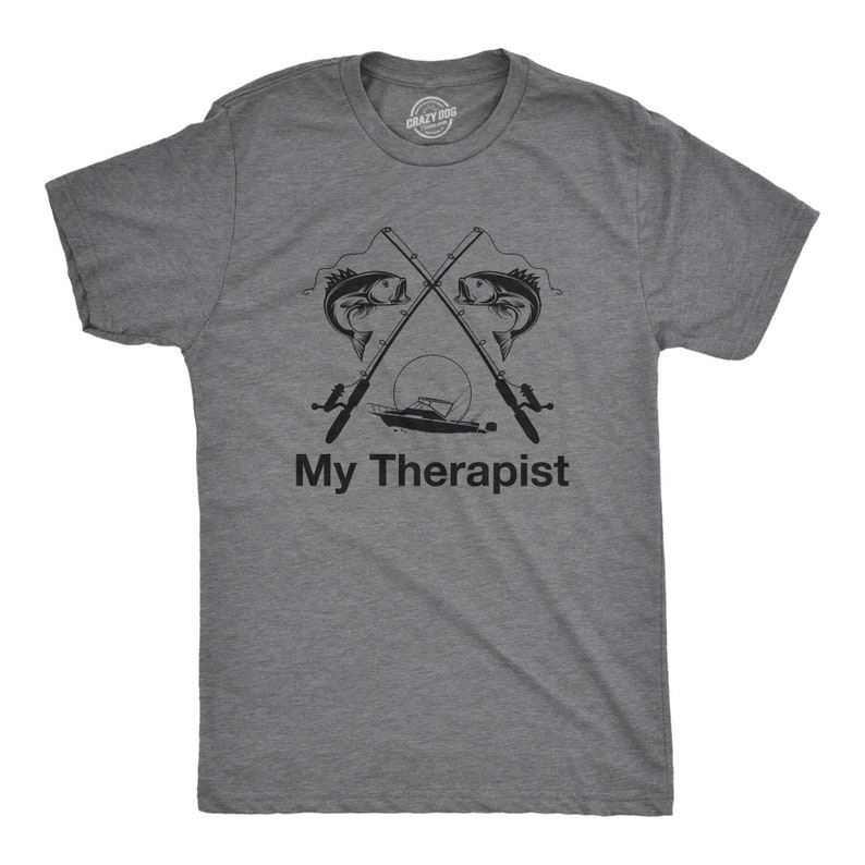 May include: A heather grey t-shirt with a graphic of two fishing rods crossed with a boat and fish. The text "My Therapist" is printed below the graphic.