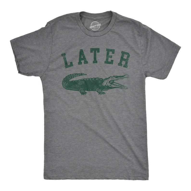 Puede incluir: Una camiseta gris jaspeada con un gr&aacute;fico de un cocodrilo verde y la palabra "LATER" impresa en una fuente universitaria vintage.