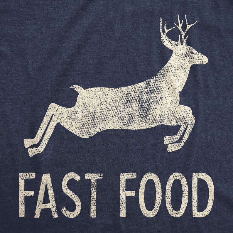 May include: Navy blue t-shirt with a distressed white graphic of a leaping deer and the words "FAST FOOD" in a bold font. The design has a vintage, worn look.