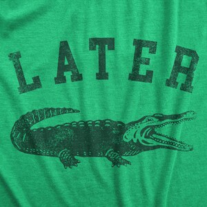 Puede incluir: Camiseta verde con un gr&aacute;fico de cocodrilo negro y la palabra "LATER" impresa en negro.