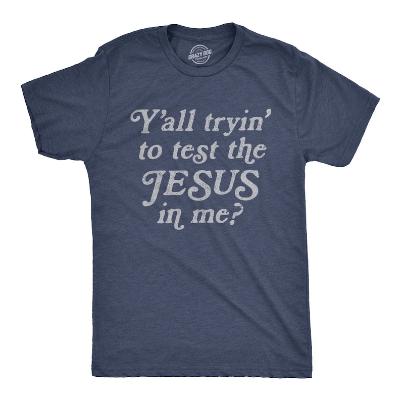 May include: A navy blue t-shirt with a white distressed graphic that reads "Y'all tryin' to test the JESUS in me?"