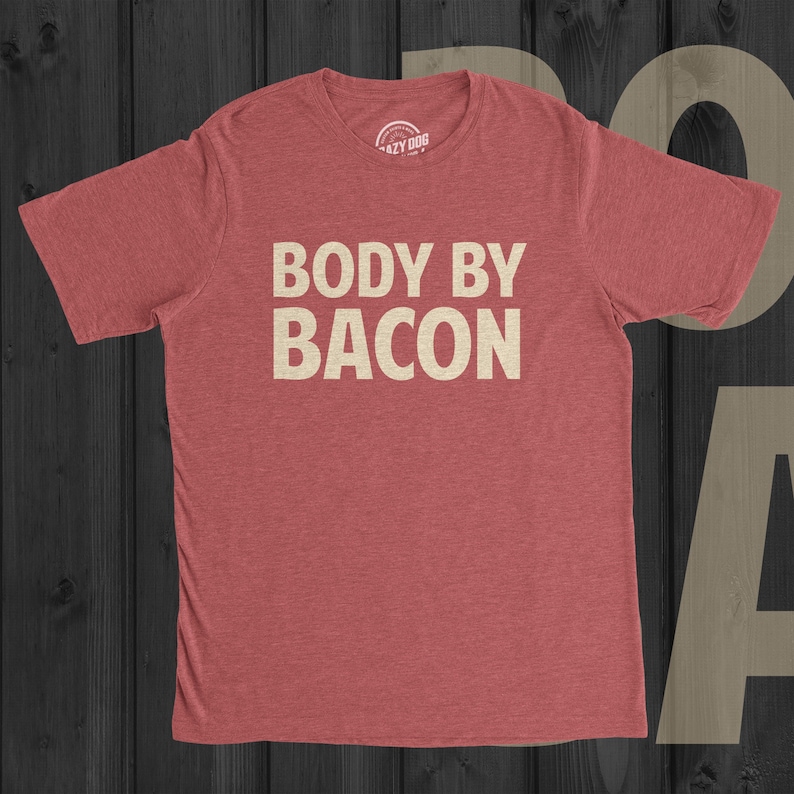 May include: Red heather t-shirt with the text "BODY BY BACON" in white.