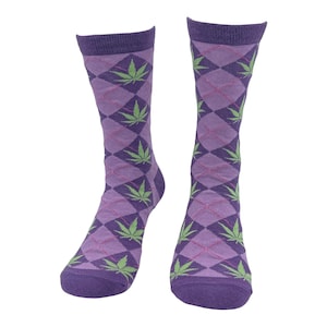Op de afbeelding: Een paar paarse sokken met een groen marihuanabladpatroon. De sokken hebben een ruitpatroon.
