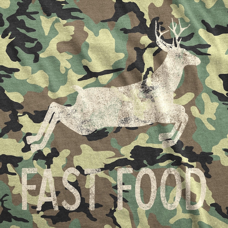 May include: A camouflage print t-shirt with a white silhouette of a deer running and the text "FAST FOOD" printed on the bottom.