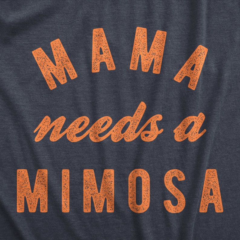 Puede incluir: Una camiseta azul marino con el texto "MAMA needs a MIMOSA" impreso en naranja.