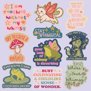 May include: A collection of whimsical stickers featuring various designs. Includes a cat with fairy wings, a frog with butterfly wings, and a mushroom character. Text includes phrases like "Stay Whimsical" and "I am nothing without my whimsy."
