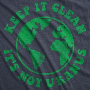 May include: Green text on a dark blue shirt reads "Keep it clean it's not Uranus". A green outline of the Earth is in the center of the text.