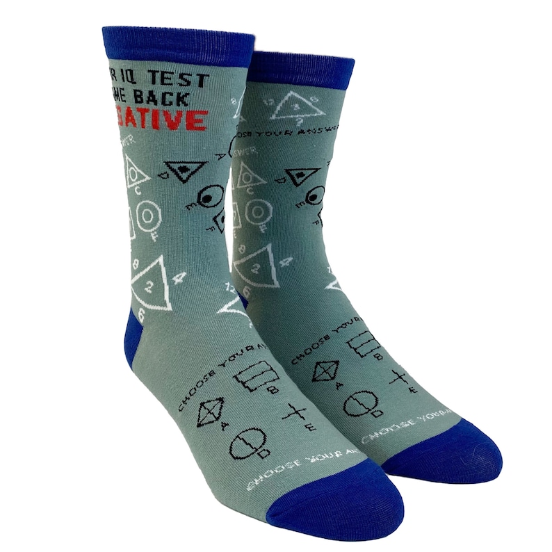 Puede incluir: Un par de calcetines grises con un pu&ntilde;o azul. Los calcetines presentan un gr&aacute;fico de un patr&oacute;n geom&eacute;trico con el texto "IQ Test Turn the Back Negative" en la parte superior.
