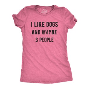 May include: Pink t-shirt with the text "I LIKE DOGS AND MAYBE 3 PEOPLE" in black. The shirt has short sleeves and a crew neck. The brand name "Crazy Dog" is printed on the tag.