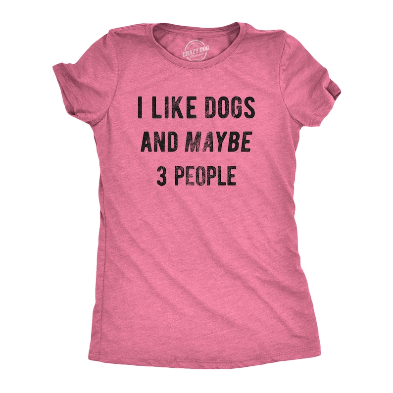 May include: Pink t-shirt with the text "I LIKE DOGS AND MAYBE 3 PEOPLE" in black. The shirt has short sleeves and a crew neck. The brand name "Crazy Dog" is printed on the tag.