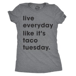 May include: A grey t-shirt with the slogan "Live everyday like it's taco tuesday." The text is in black, and the shirt has short sleeves and a crew neck. The brand name "Crazy Dog" is printed at the top.