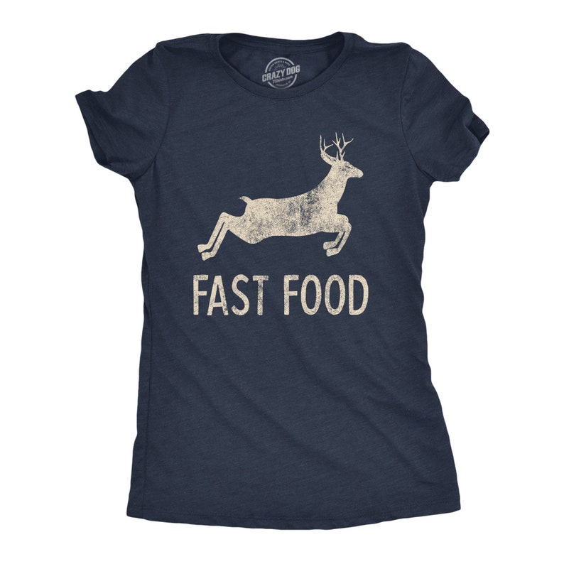 May include: Navy blue t-shirt with a distressed graphic of a leaping deer and the words "FAST FOOD" in a bold, sans-serif font. The shirt has short sleeves and a crew neck.