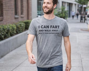 Op de afbeelding: Een grijs gemêleerd T-shirt met korte mouwen en de zwarte opdruk I CAN FART AND WALK AWAY - WHAT'S YOUR SUPERPOWER? Het shirt heeft een ronde hals en een standaard pasvorm, gemaakt van een zachte en lichtgewicht stofmix.