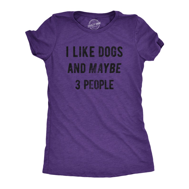 May include: A purple t-shirt with the text "I LIKE DOGS AND MAYBE 3 PEOPLE" in black. The shirt has short sleeves and a crew neck. The Crazy Dog T-shirts logo is visible at the top.