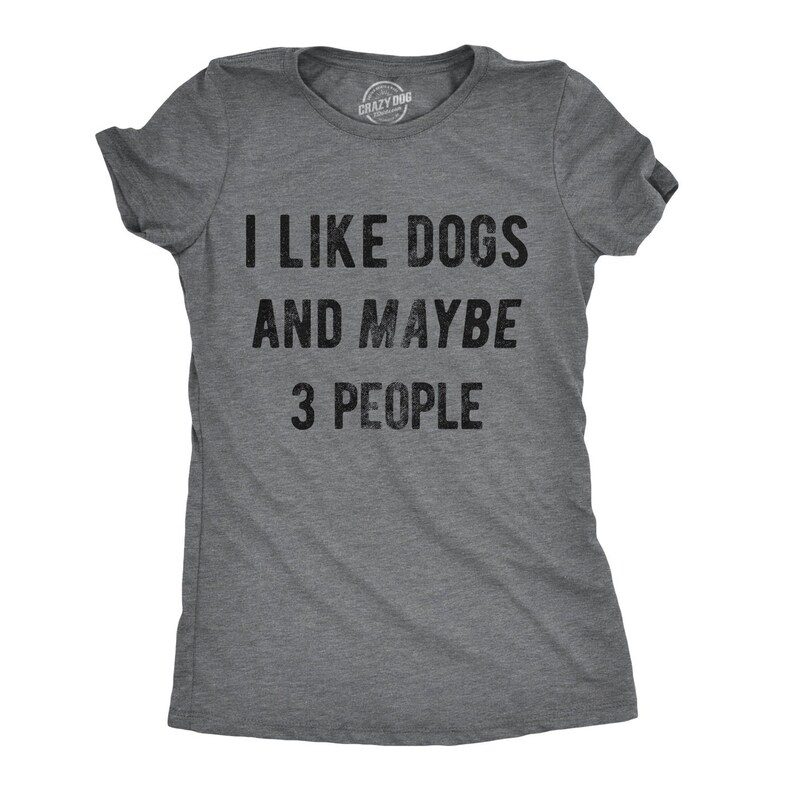May include: Gray t-shirt with the text "I LIKE DOGS AND MAYBE 3 PEOPLE" in black. The shirt has short sleeves and a crew neck. The brand logo "Crazy Dog" is visible at the top.