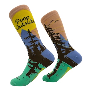 以下が含まれることがあります： 自然をテーマにしたデザインのノベルティソックスのペア。靴下は、「Poop Outside」というテキストが入った黄色い太陽、青い山脈、森のシーンが特徴です。靴下は緑色のフットベッドとタンカラーのアッパーを備えています。