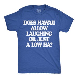 May include: A royal blue short-sleeved t-shirt featuring white distressed text that reads: DOES HAWAII ALLOW LAUGHING OR JUST A LOW HA? The shirt has a crew neckline and a small circular logo printed on the inside of the collar area.