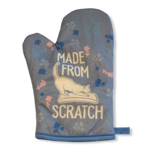 May include: Blue oven mitt with a white cat scratching a scratching post and the text "Made from Scratch".