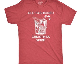 Könnte beinhalten: Ein kurzärmeliges T-Shirt in meliertem Rot mit einer weißen Grafik eines Cocktailglases, das Eiswürfel, eine Zuckerstange und einen Tannenzweig enthält. Der Text OLD FASHIONED CHRISTMAS SPIRIT ist in Weiß über und unter dem Bild gedruckt.