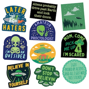 May include: A collection of ten colorful vinyl stickers featuring extraterrestrial themes, UFOs, and humorous text including phrases like Later Haters, Amateur Proctologist, I'm An Outsider, Roswell 1947, Mom Come Pick Me Up, and Believe In Yourself.