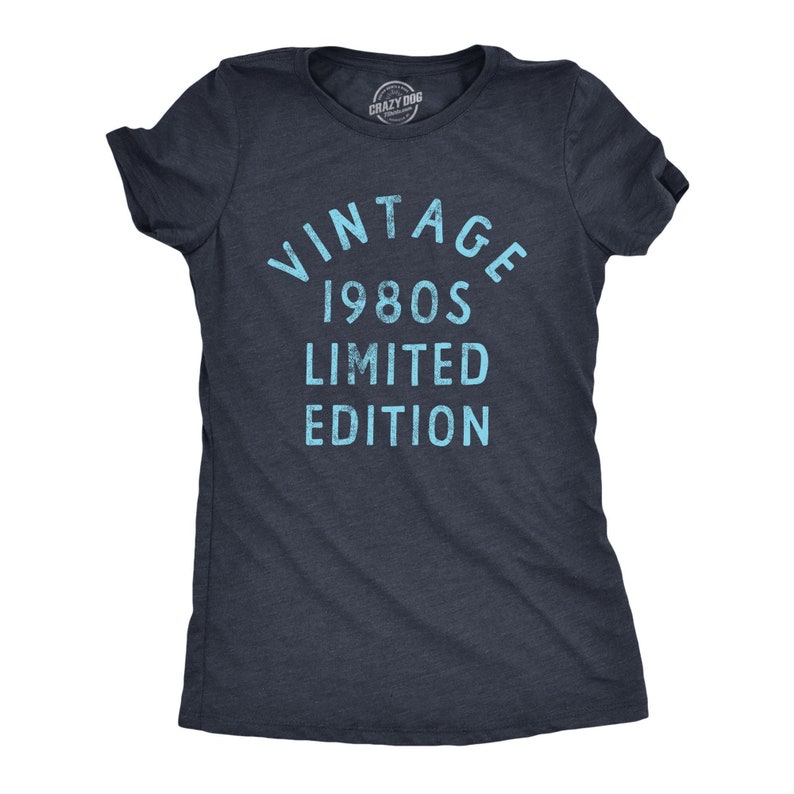 May include: Dark navy blue t-shirt with the text "VINTAGE 1980S LIMITED EDITION" in light blue. The shirt has short sleeves and a crew neck. The Crazy Dog brand logo is visible at the top.