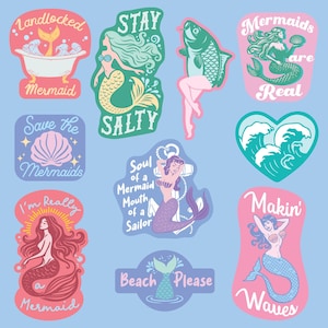 Op de afbeelding: Een verzameling kleurrijke stickers met zeemeermintthema. Ontwerpen omvatten zeemeerminnen, schelpen en zinnen als "Stay Salty" en "Mermaids are Real". De stickers staan op een lichtblauwe achtergrond.