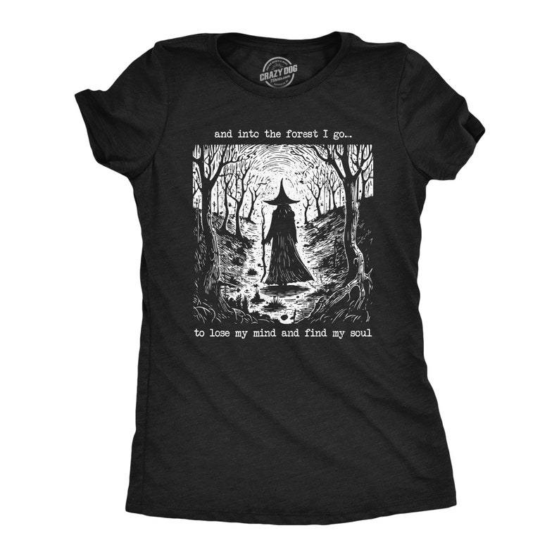 Puede incluir: Camiseta negra con un gr&aacute;fico blanco de una persona con un sombrero de bruja caminando hacia un bosque. El texto "and into the forest I go... to lose my mind and find my soul" est&aacute; impreso debajo del gr&aacute;fico.